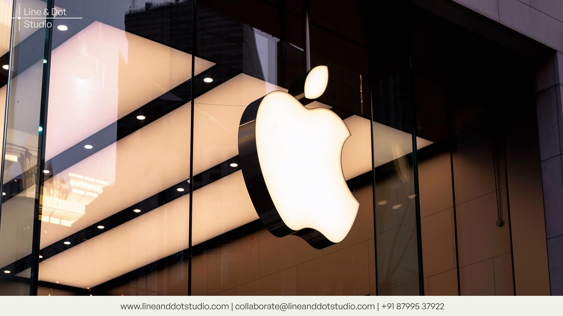 Front of an Apple store with Apple logo sign on a glass facade