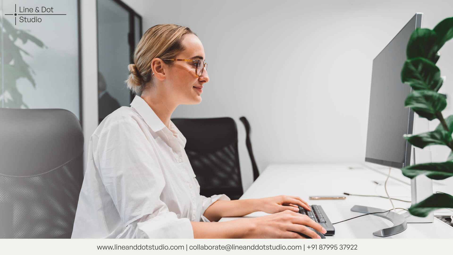 a woman working and sitting in front of a desktop